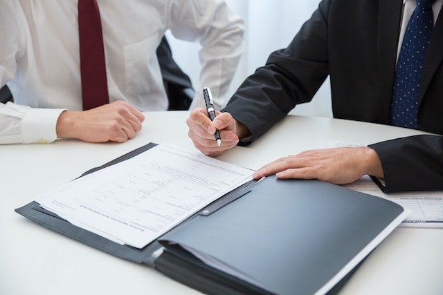 a landlord and tenant looking at a folder full of papers